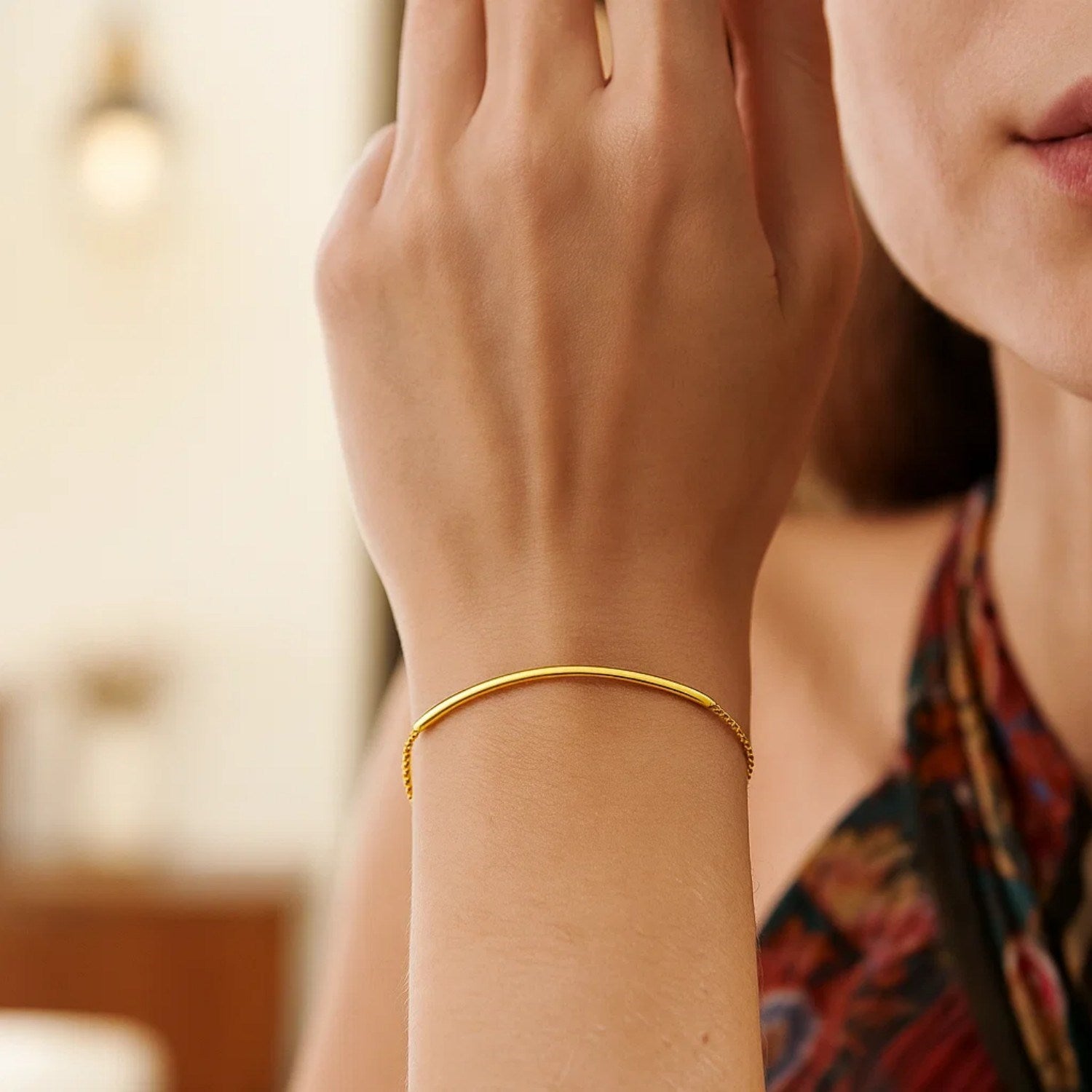 14k yellow gold smooth curved bar lariat bracelet featuring a delicate chain for a modern, elegant touch.