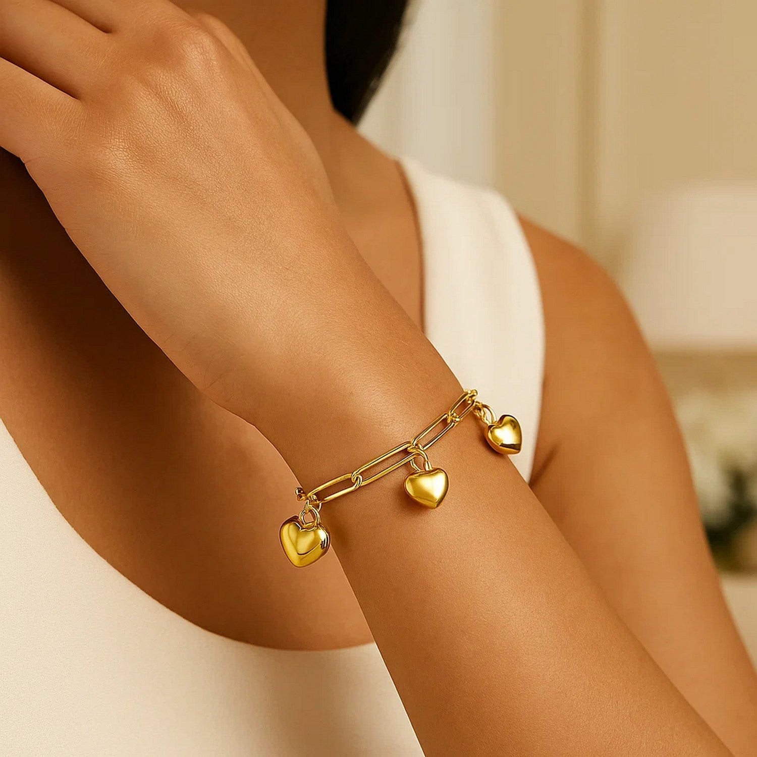 14k yellow gold puffed heart charm bracelet with elegant chain design, perfect for adding a touch of luxury to any outfit.