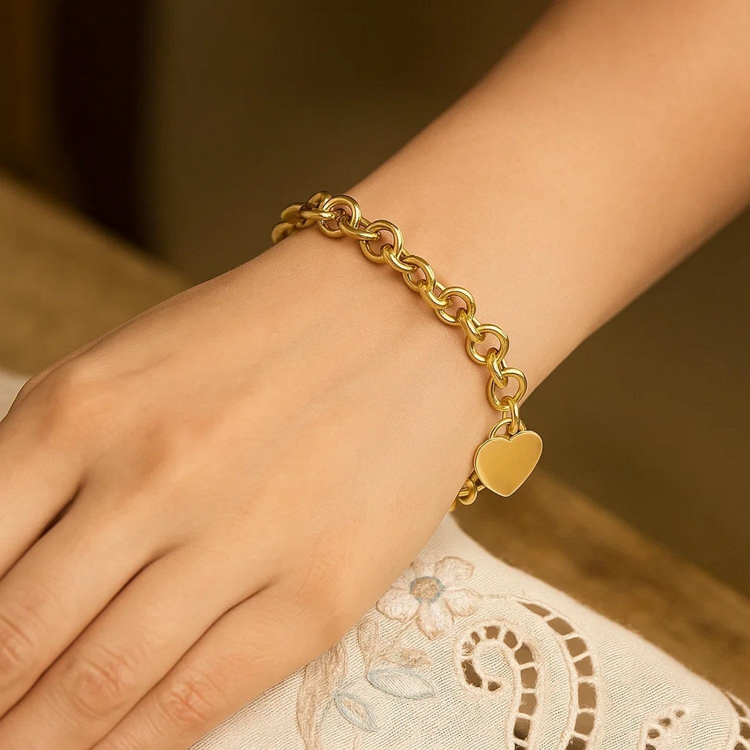 Elegant 14k yellow gold heart tag bracelet with rolo link design, showcasing timeless luxury and sophistication.