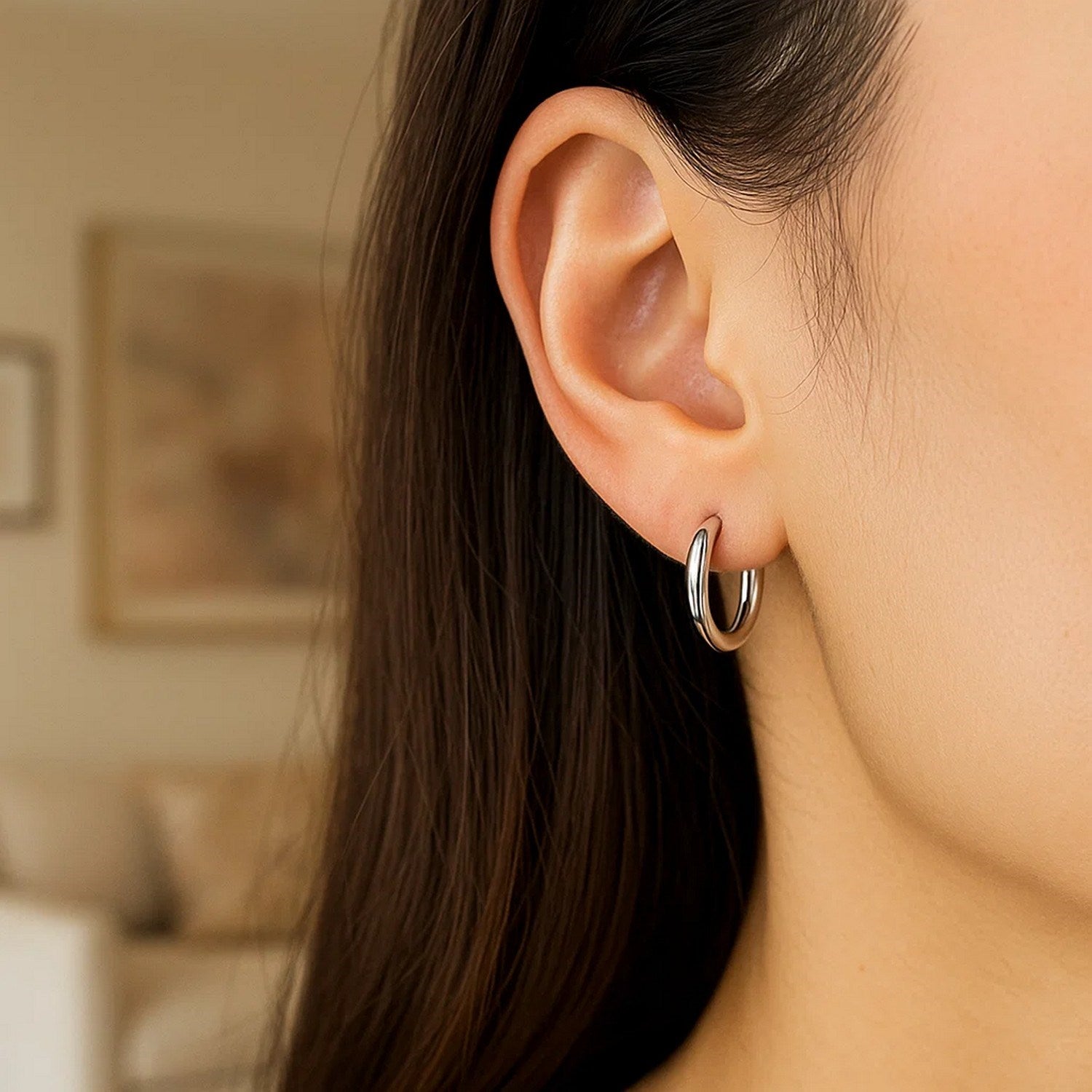 Sterling silver polished hoop earrings with rhodium plating, showcasing a sleek modern design and elegant shine.