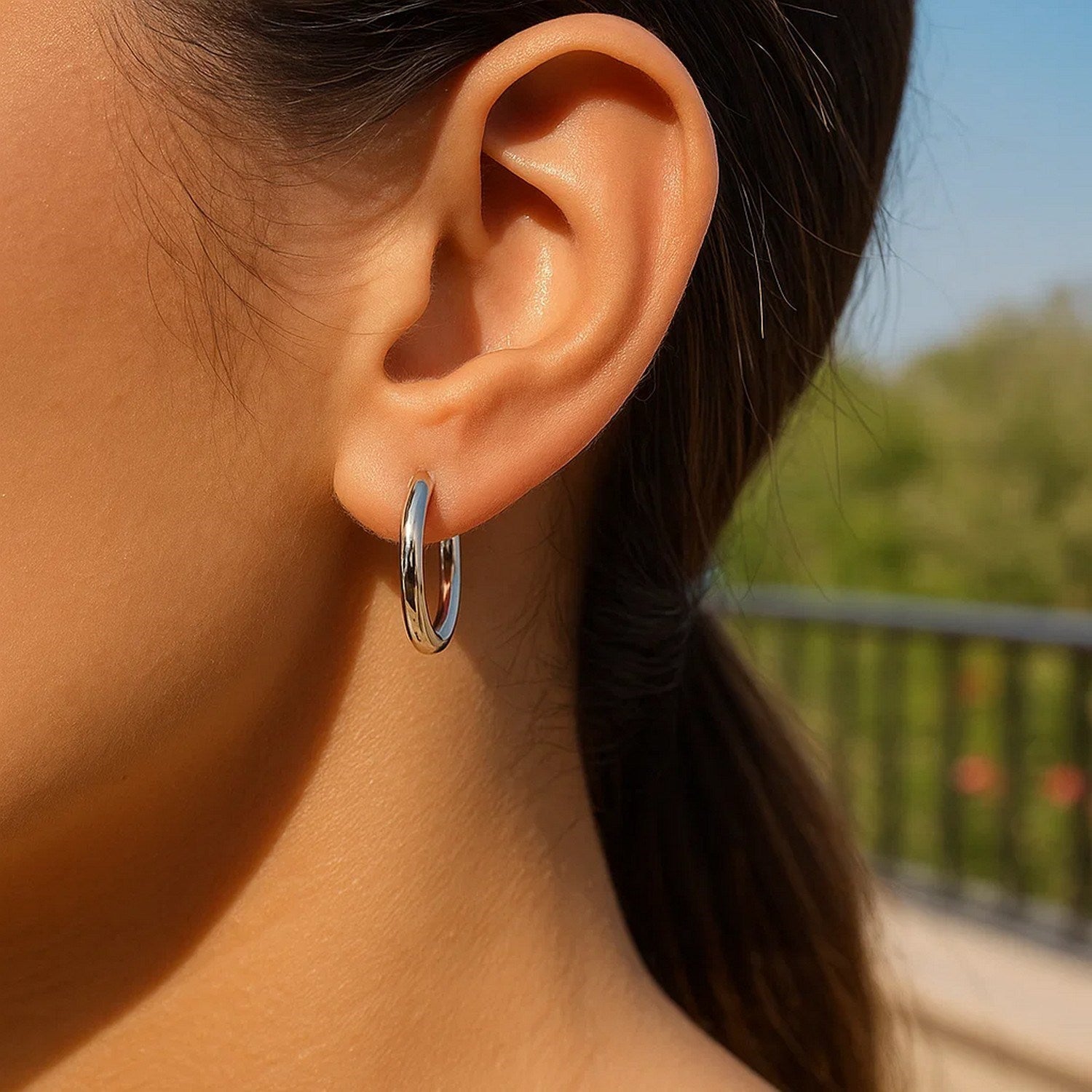 Sterling silver polished hoop earrings with rhodium plating, showcasing a modern and elegant design.