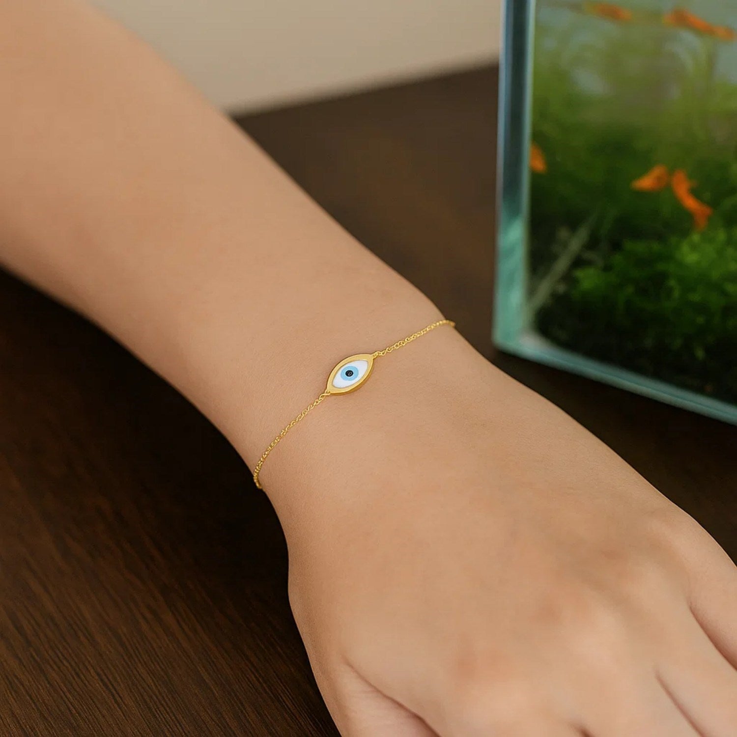 Elegant 14k yellow gold bracelet featuring a MOP evil eye design on a delicate chain, perfect for luxury styling.