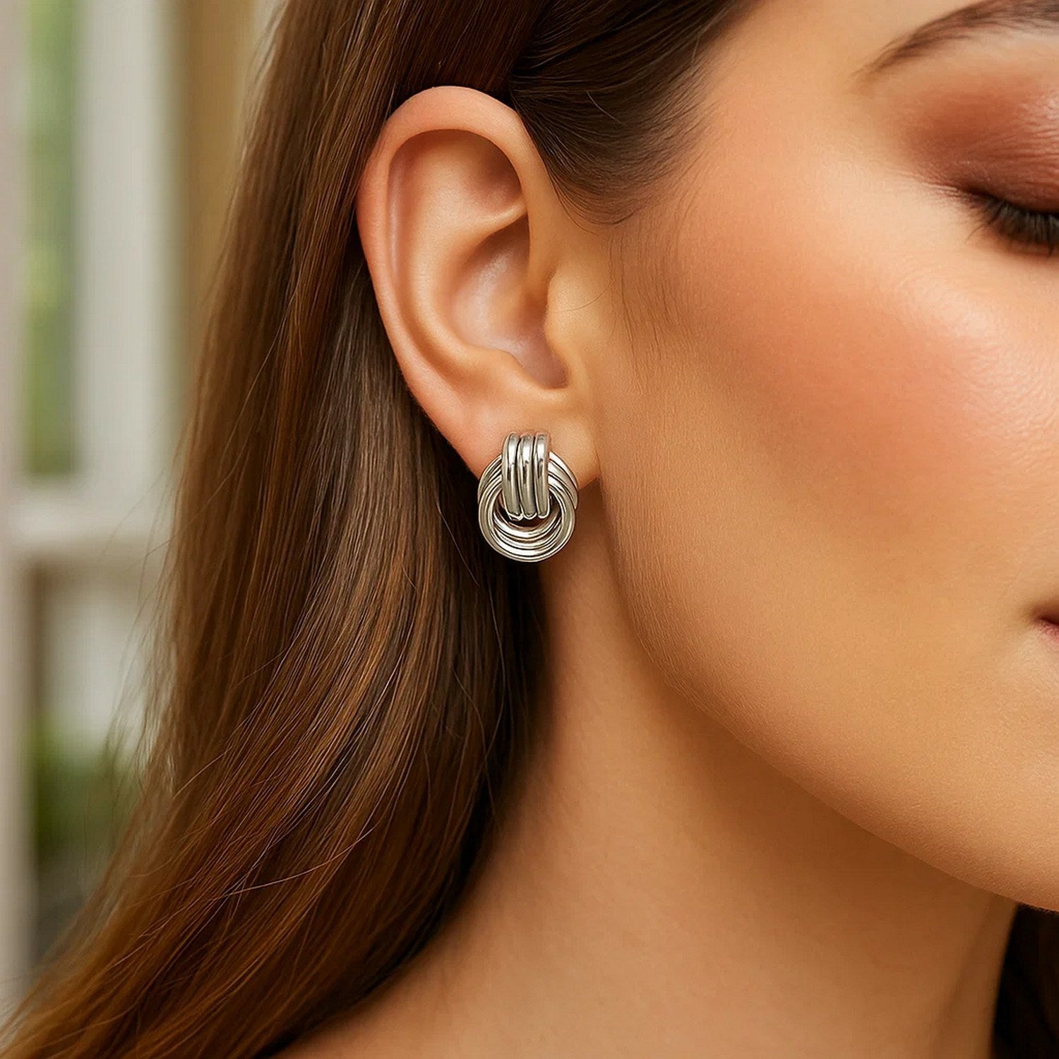 Polished sterling silver love knot earrings featuring interlocking rings in a modern design, 15mm for a luxurious touch.