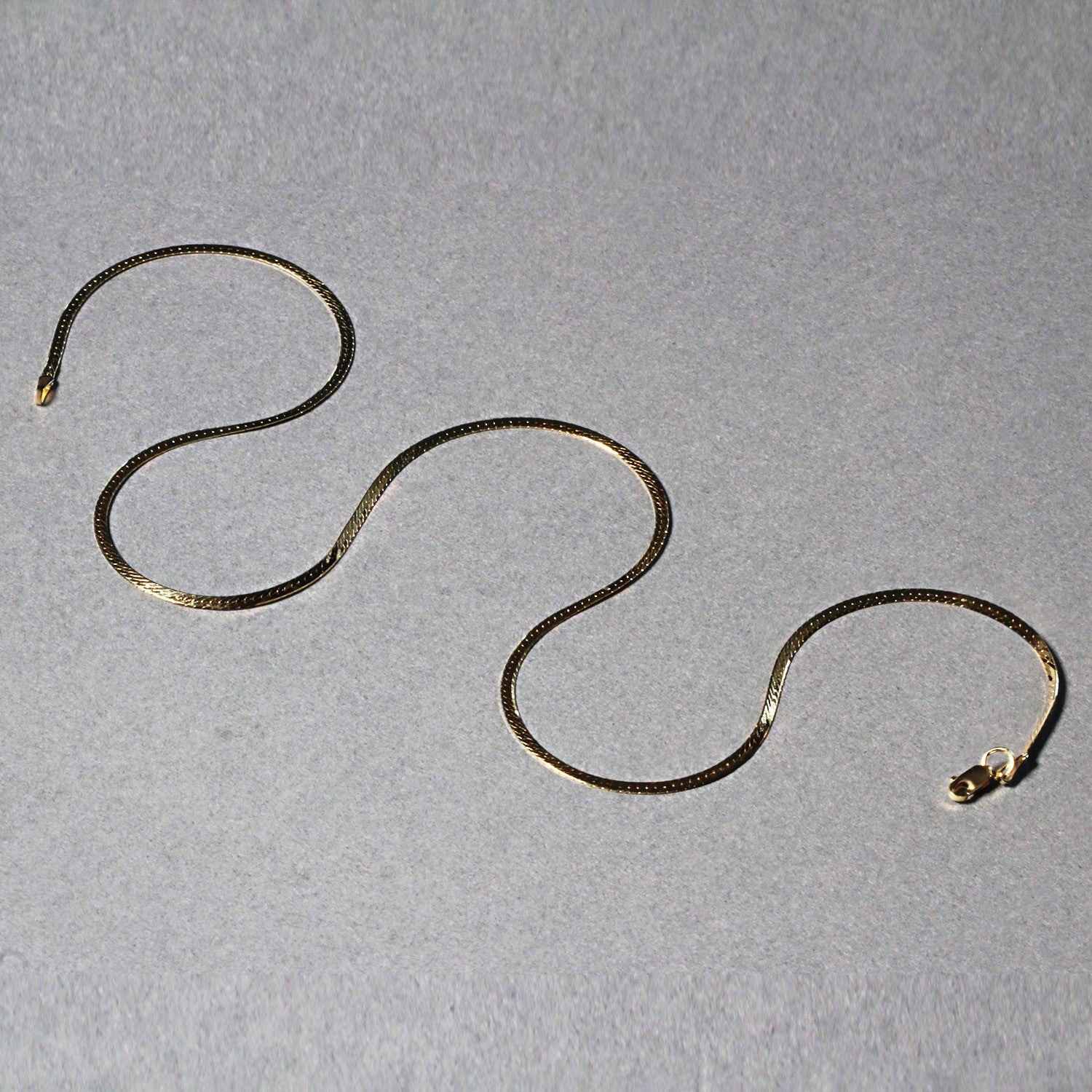 Elegant 14k yellow gold super flex herringbone chain, 1.50 mm, showcasing a sleek, refined design.