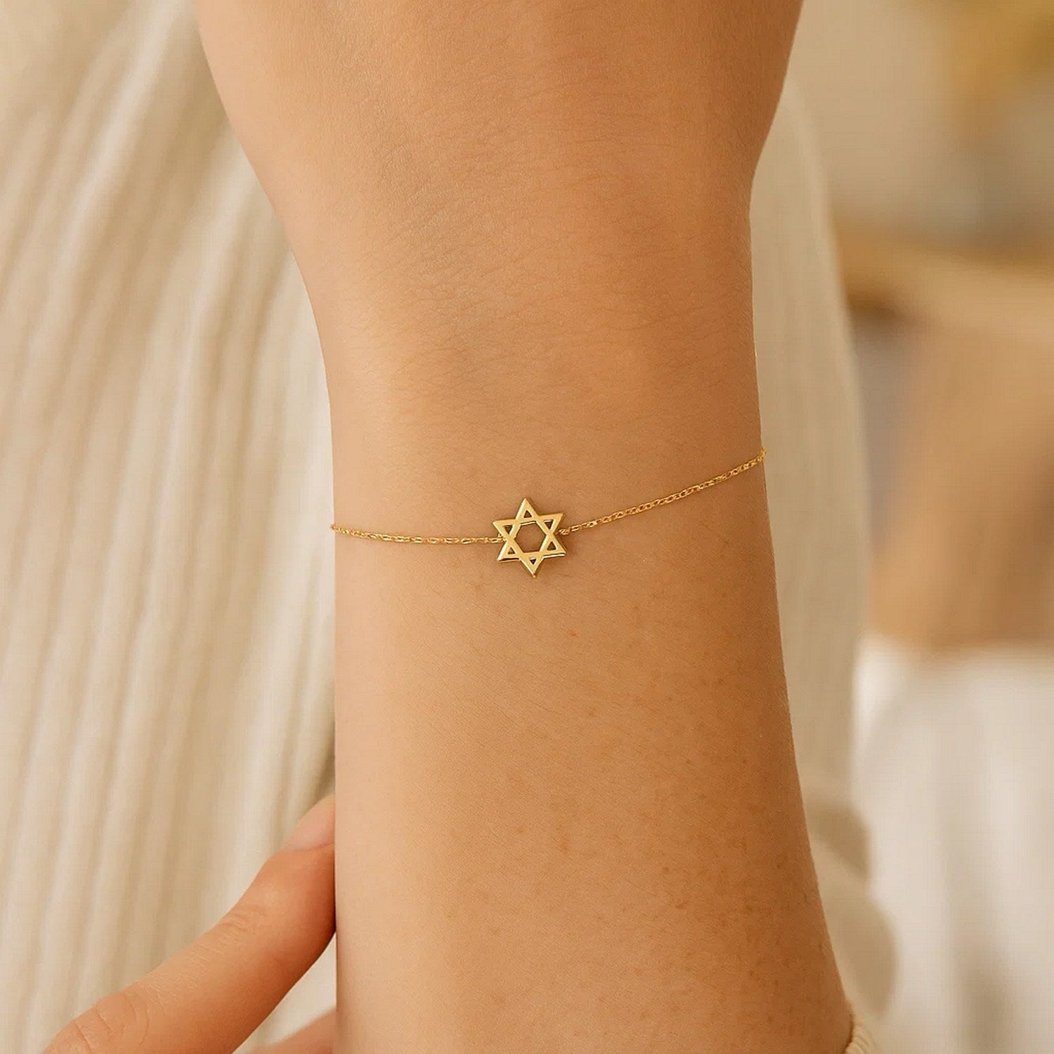 Elegant 14k yellow gold Star of David bracelet featuring a delicate chain design, perfect for sophisticated styling.