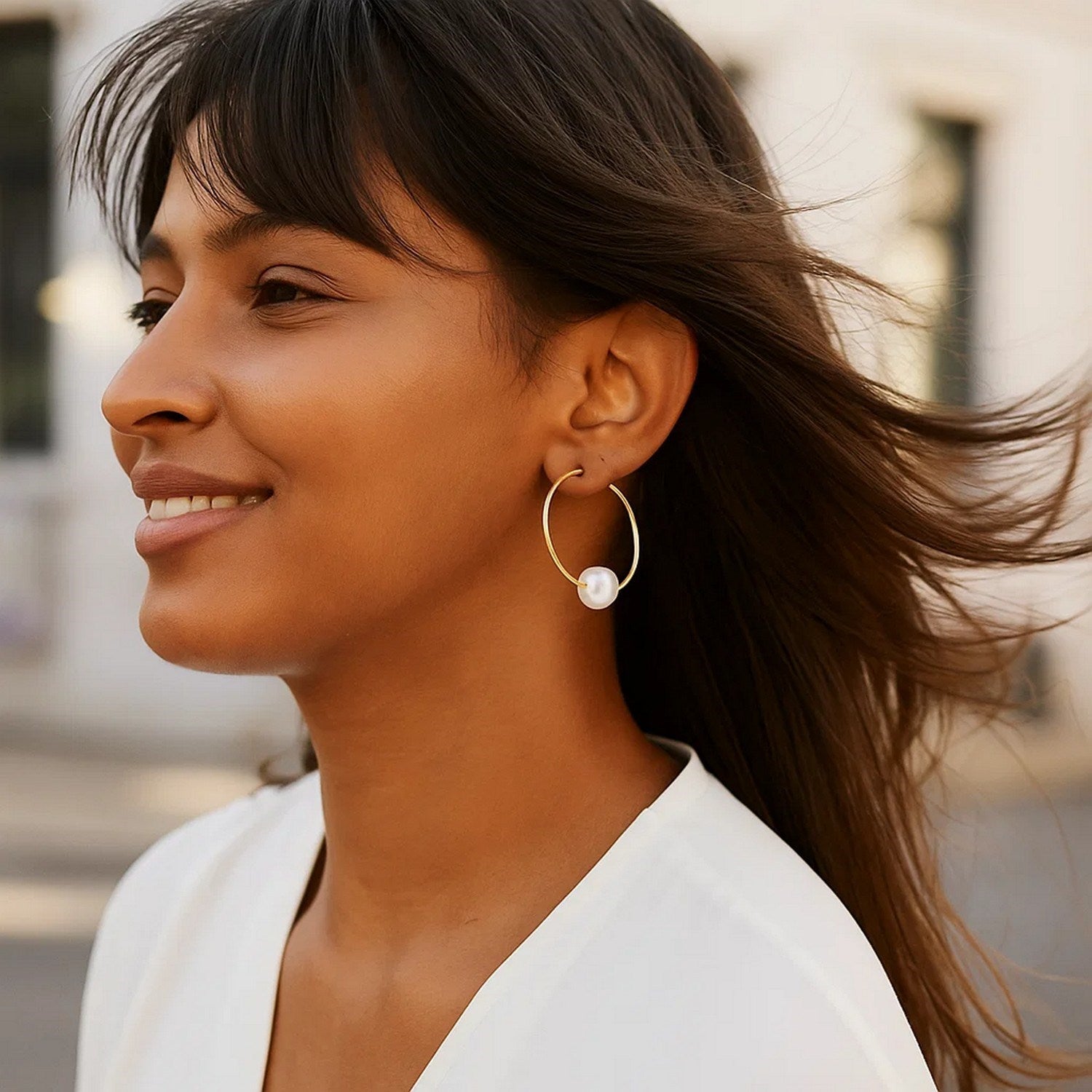 Elegant 14k yellow gold endless pearl hoop earrings featuring lustrous round pearls and a timeless design.