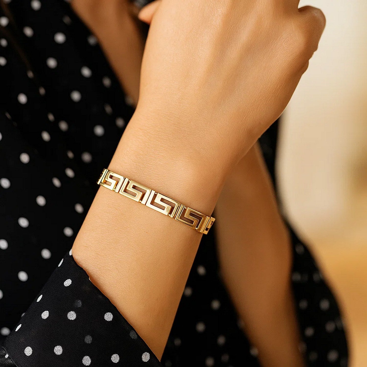 Elegant 14k yellow gold bracelet featuring a sophisticated Greek key motif and a delicate chain design.