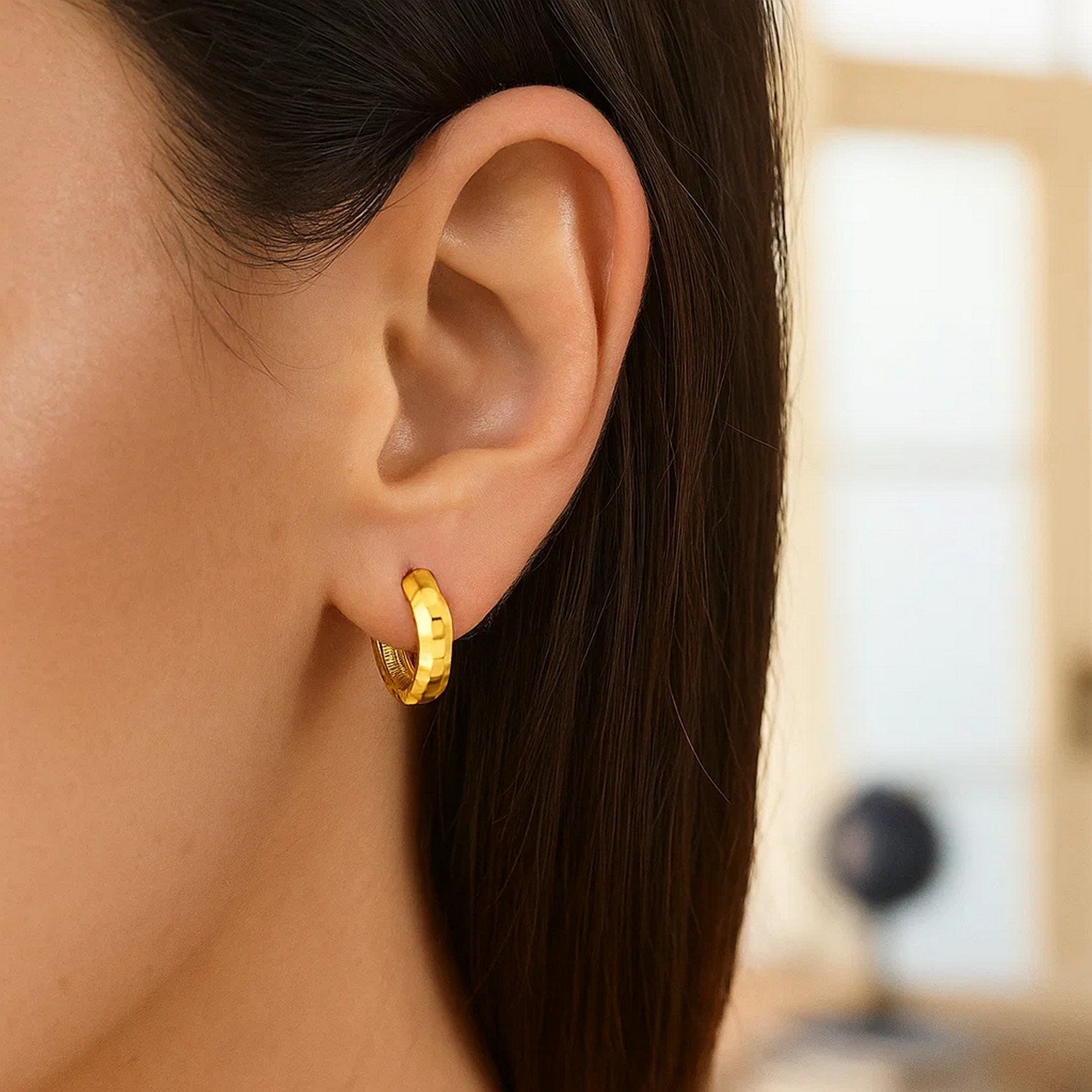 14K yellow gold polished huggie hoop earrings with a sleek modern design, perfect for elegant everyday wear.