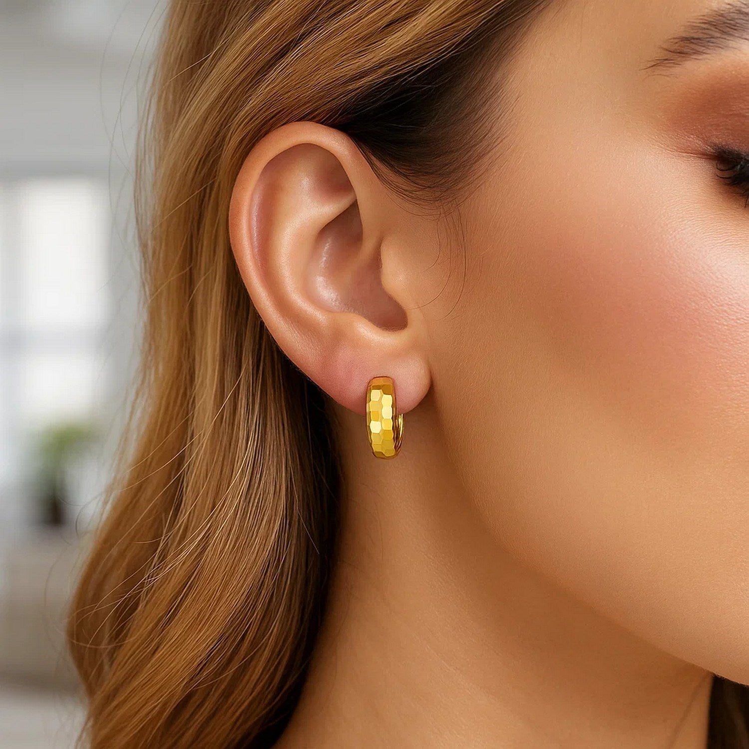 14K yellow gold polished huggie hoop earrings with a sleek modern design, perfect for elegant everyday wear.