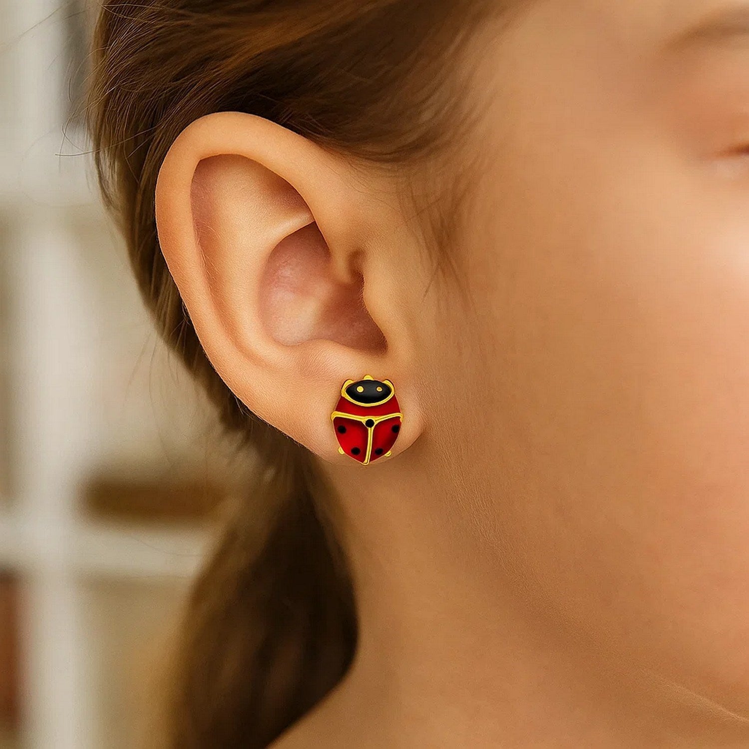 Elegant 14k yellow gold ladybug stud earrings, showcasing intricate detailing and a luxurious finish.