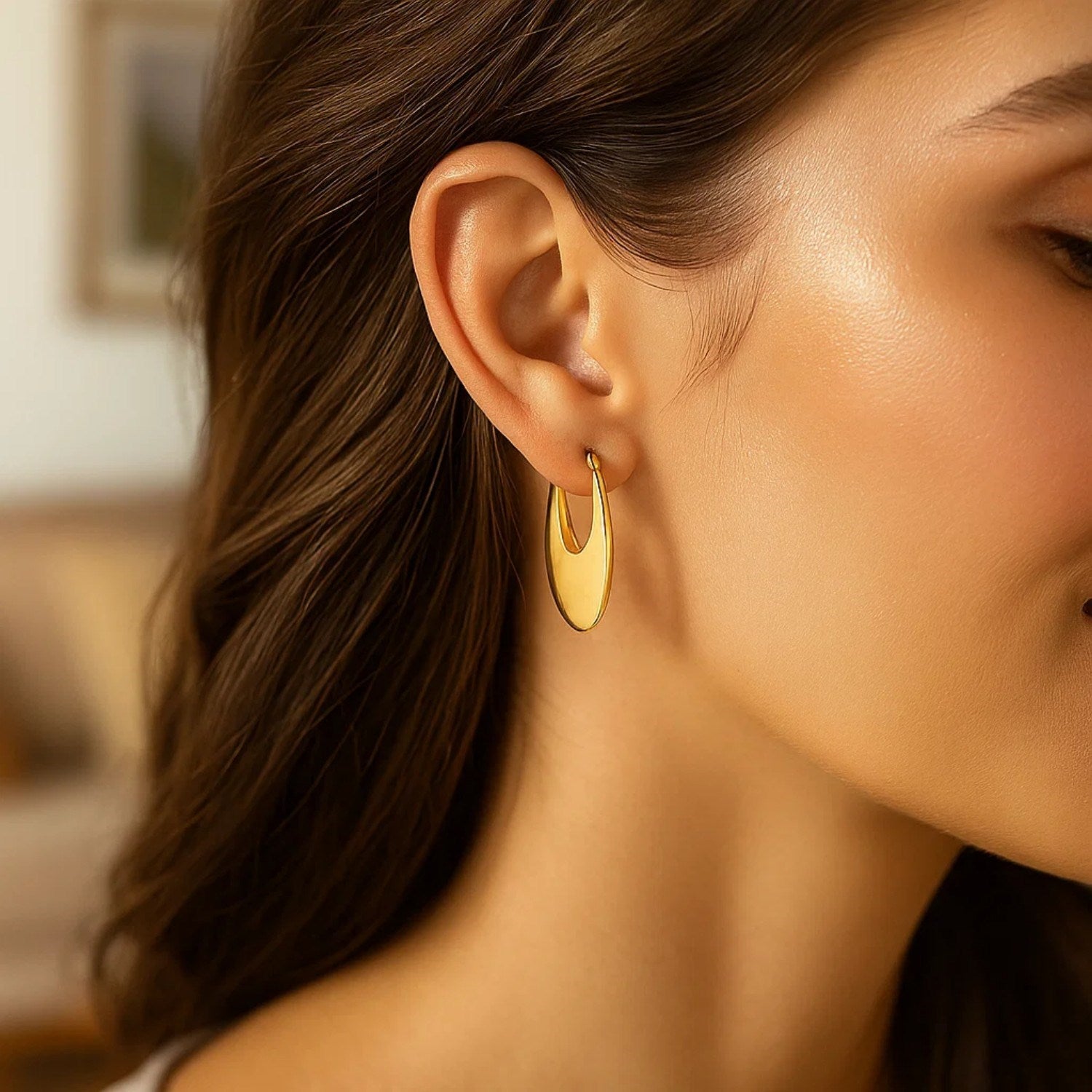 Elegant 14k yellow gold oval hoop earrings showcasing a refined design, perfect for sophisticated occasions.
