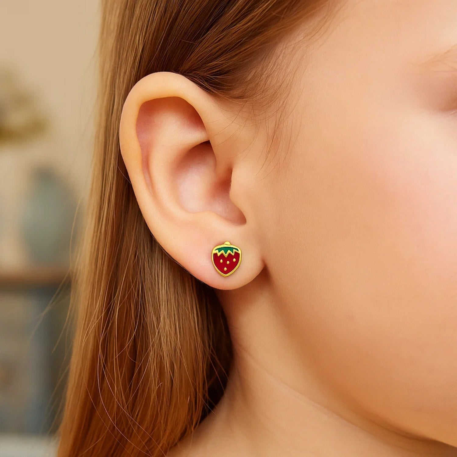 Elegant 14k yellow gold enameled strawberry stud earrings, showcasing a playful yet sophisticated design.