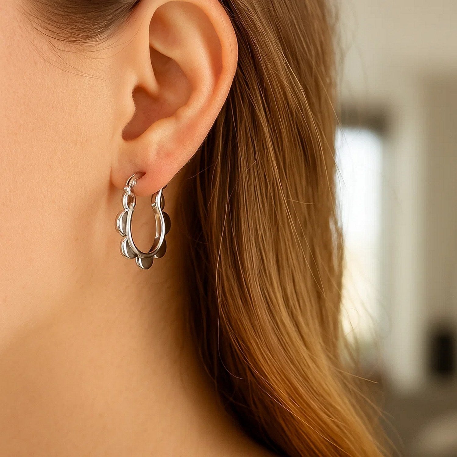 14k white gold scalloped hoop earrings showcasing a modern design with elegant curves and a polished finish.