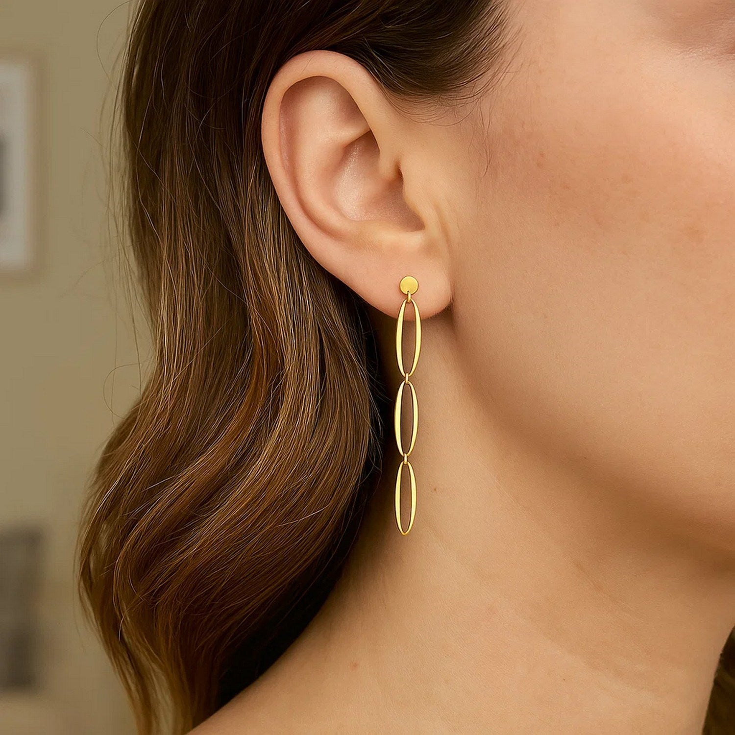 14k yellow gold elegant triple oval drop earrings, showcasing a refined design perfect for sophisticated occasions.