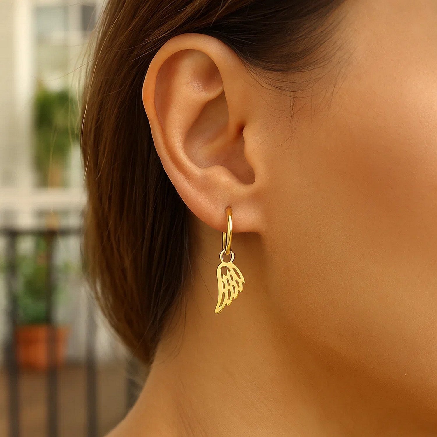 14k yellow gold hoop earrings featuring delicate angel wings in a contemporary design, perfect for elegant occasions.