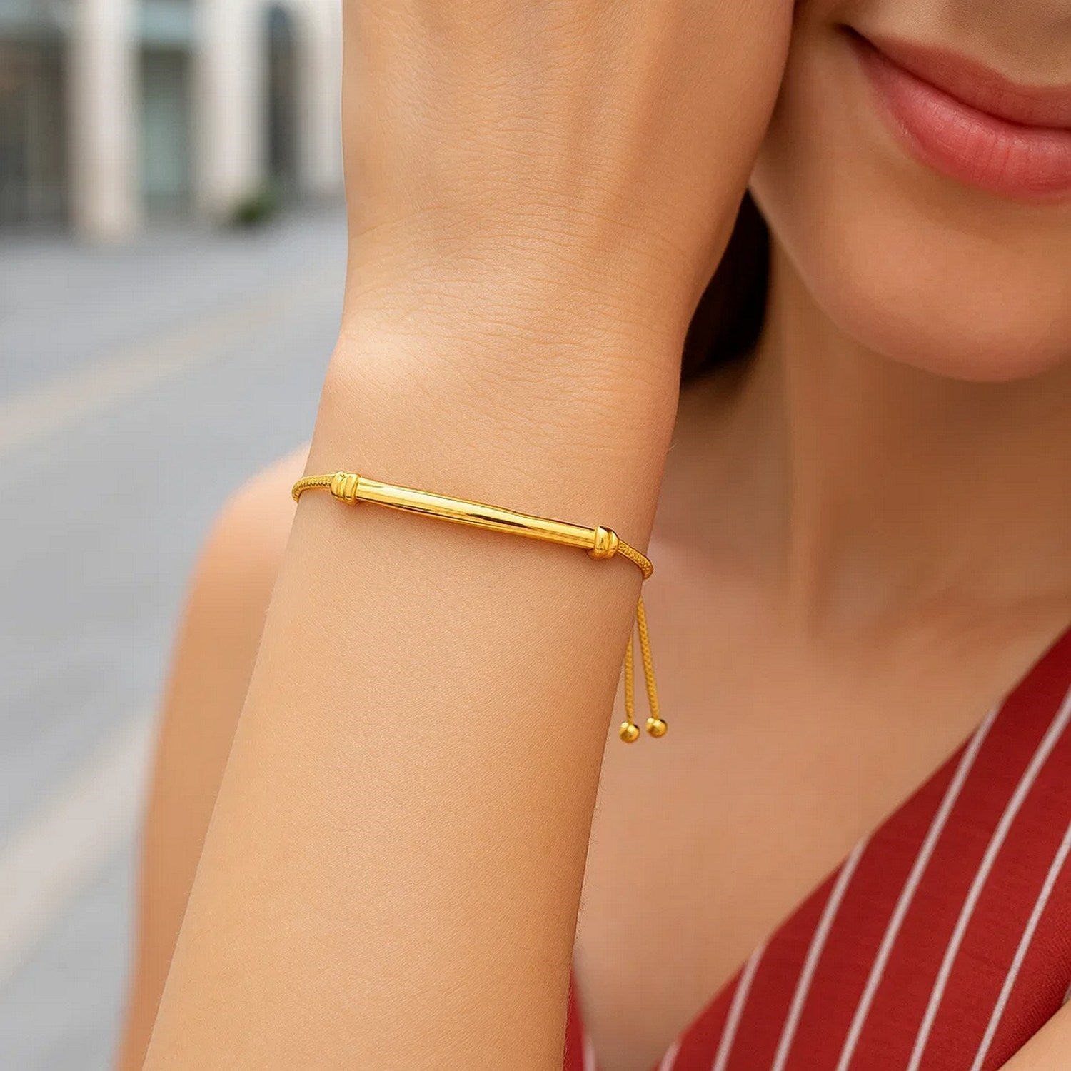 14k yellow gold lariat bracelet featuring a smooth curved bar design and sparkling diamond accents.
