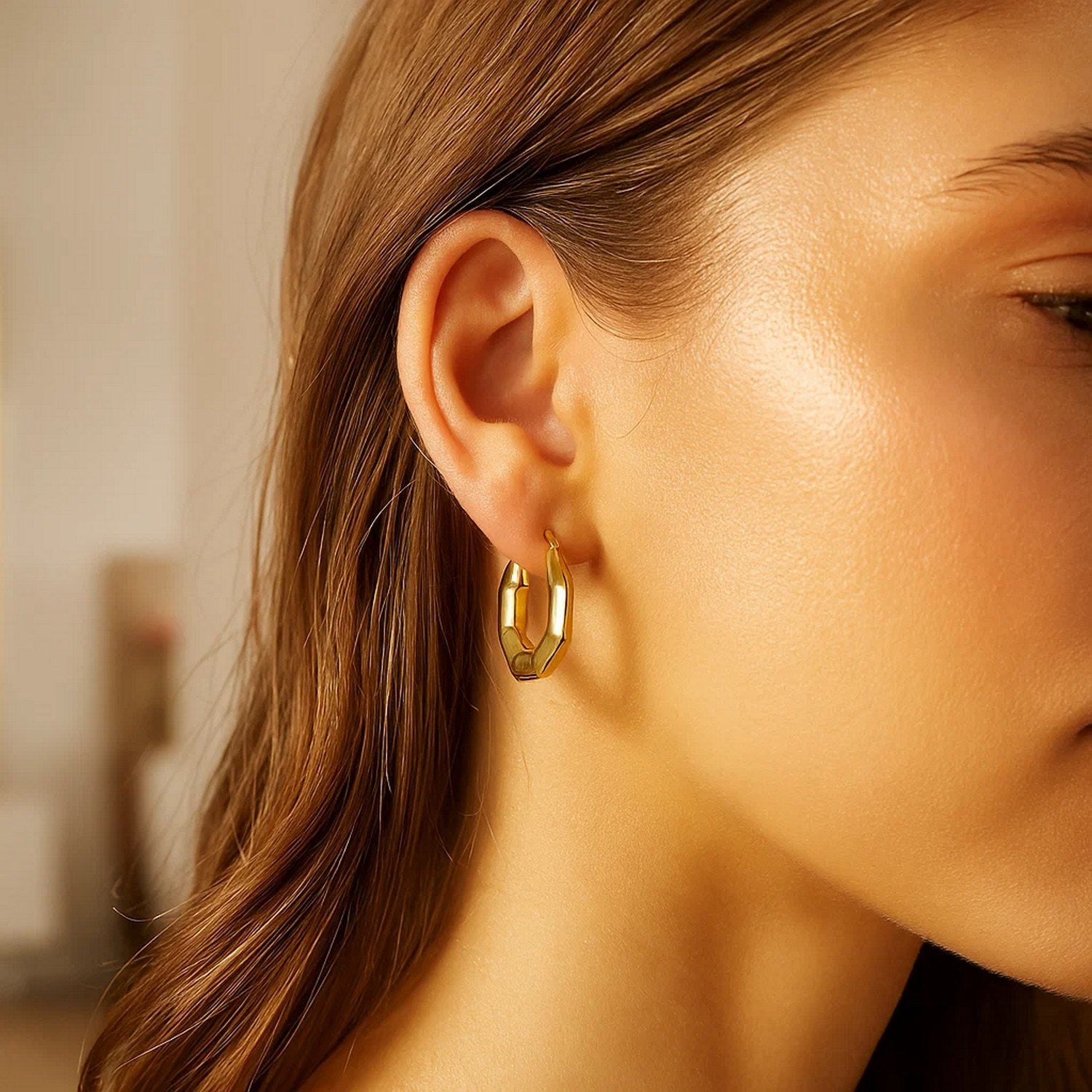Polished 14k yellow gold hoop earrings showcasing a modern design with a luxurious finish.