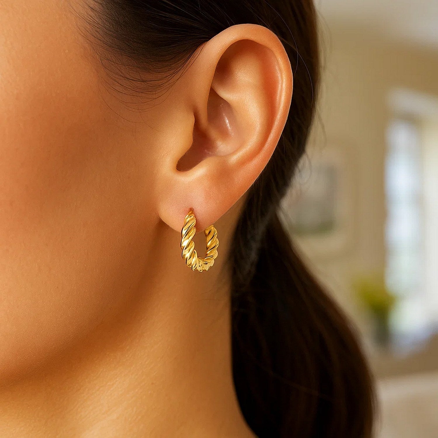 Elegant 14k yellow gold polished twisted hoop earrings, showcasing a refined design for timeless luxury.