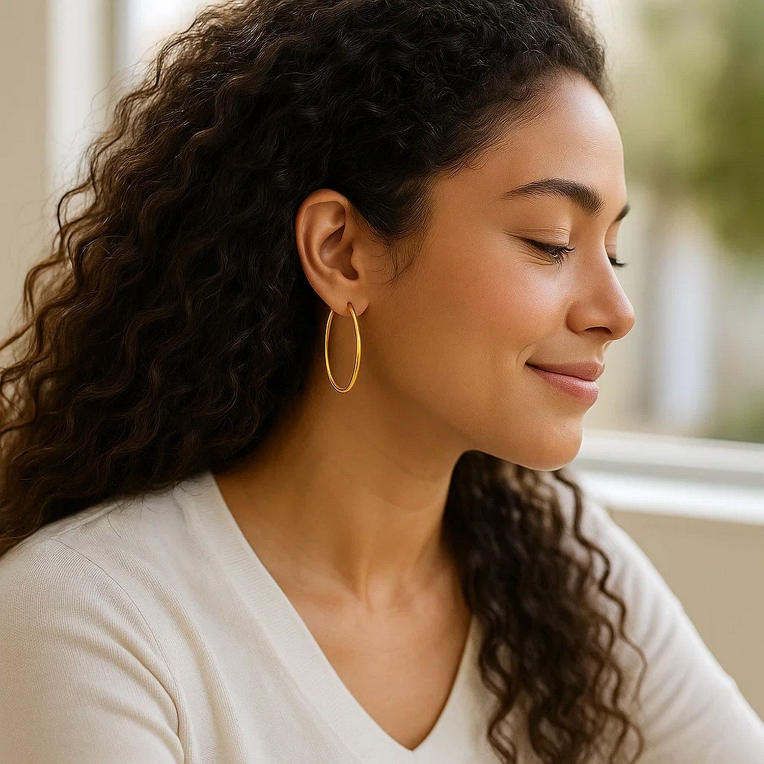 14k yellow gold slim oval hoop earrings with a modern design, perfect for elegant everyday wear.