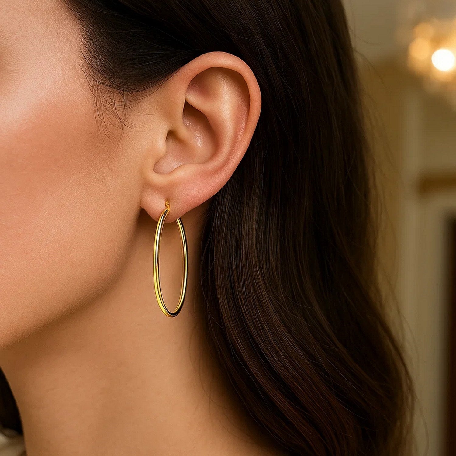 14k yellow gold slim oval hoop earrings with a modern design, perfect for elegant everyday wear.