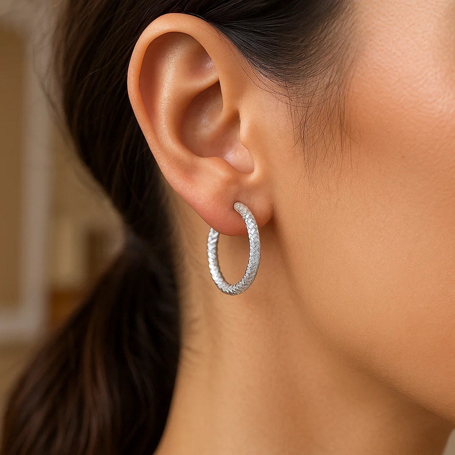 Sterling silver large hoop earrings with intricate braid texture, showcasing modern elegance and timeless style.
