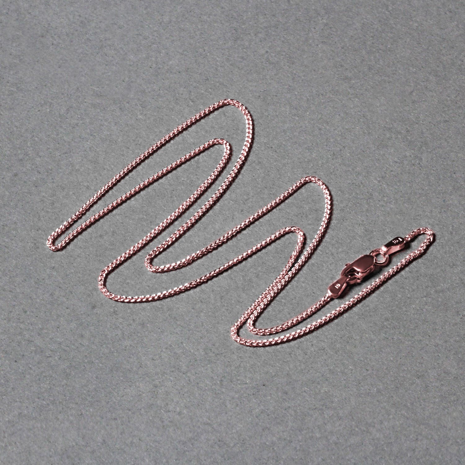 Elegant 14k rose gold round wheat chain, 1.00 mm, showcasing a refined design perfect for layering or standalone wear.