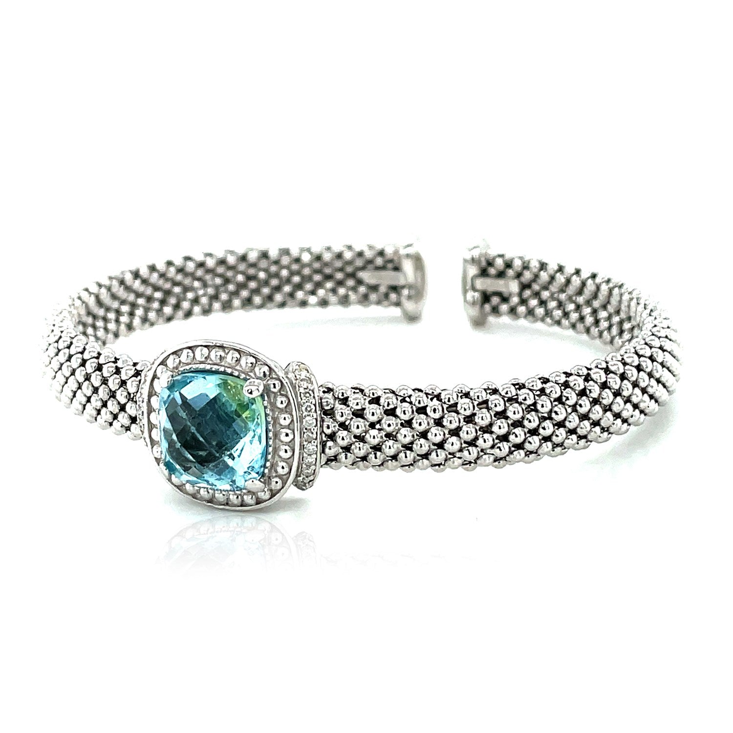 Sterling silver cuff bangle with popcorn texture, featuring blue topaz and prong-set diamonds for a modern elegance.