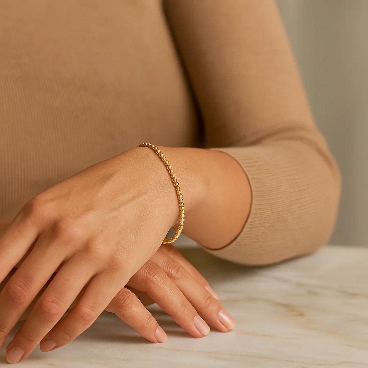Elegant 14k yellow gold stretch bracelet featuring moon cut beads and diamond stud accents for a luxurious touch.