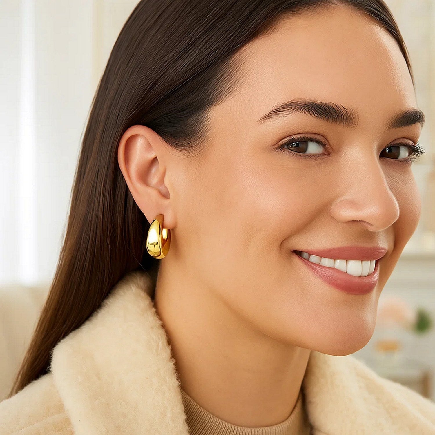 Large tapered hoop earrings in 14k yellow gold, showcasing a modern design with elegant curves and a polished finish.