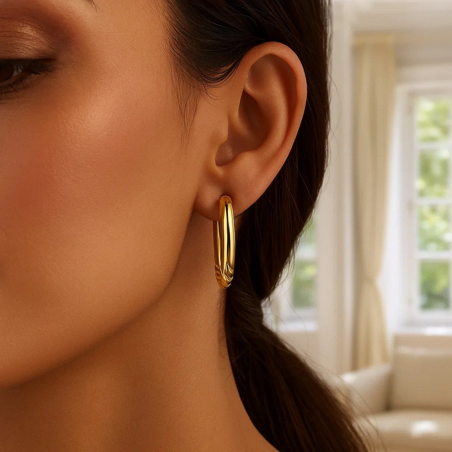 Polished 14k yellow gold large hoop earrings showcasing a modern design and luxurious shine.