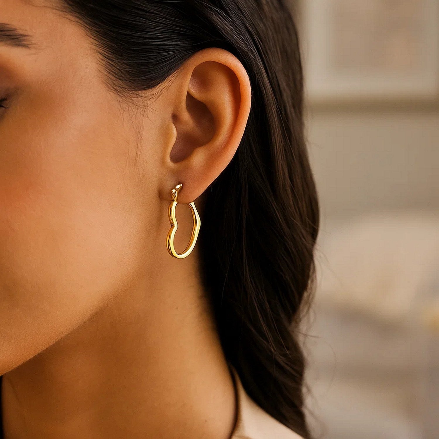 Contemporary 10k yellow gold heart hoop earrings crafted from 14k gold, showcasing elegant design and luxurious appeal.