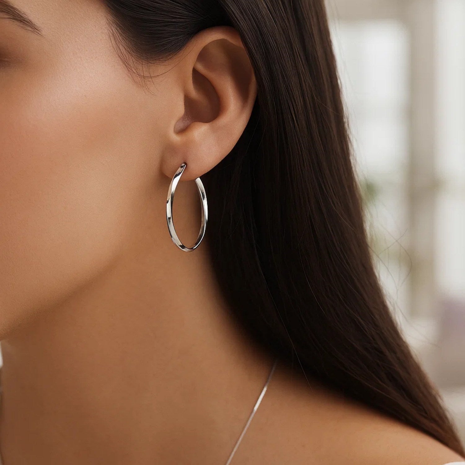 14k white gold Mobius twisted hoop earrings showcasing a modern design with elegant curves and a polished finish.