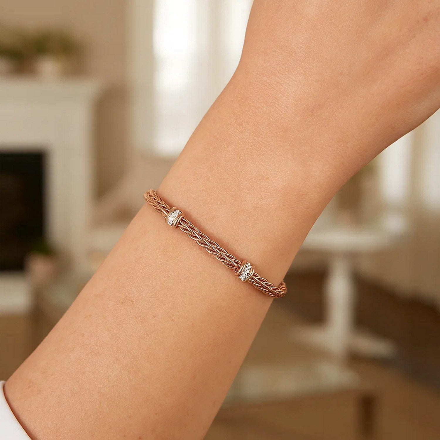 Polished 14k rose gold woven rope bracelet with round diamonds in elegant prong settings, showcasing modern luxury.