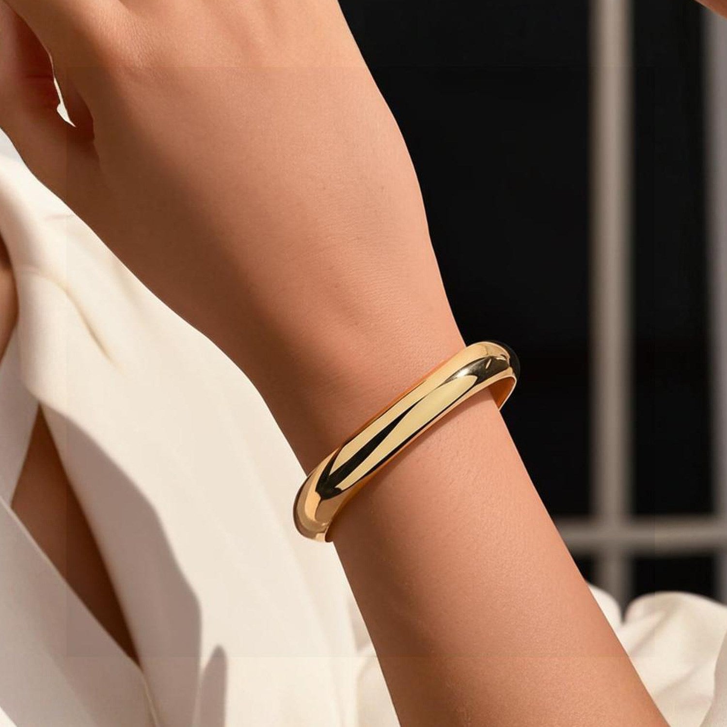 Classic 14k yellow gold bangle with a sleek modern design, showcasing luxurious simplicity and elegance.