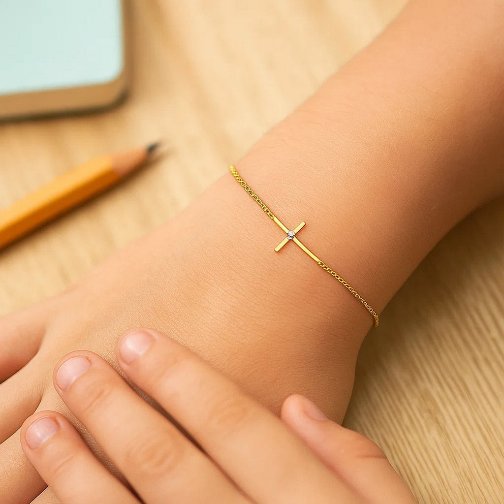 14k yellow gold children's bracelet featuring an elegant cross design on a delicate chain, perfect for young ones.