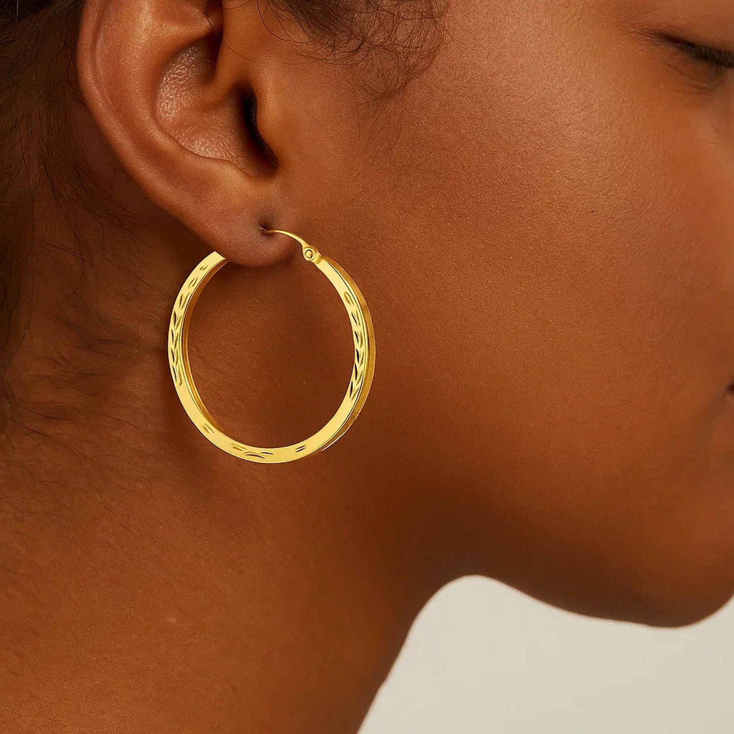 14k yellow gold diamond cut hoop earrings showcasing a modern design with exquisite craftsmanship and radiant sparkle.