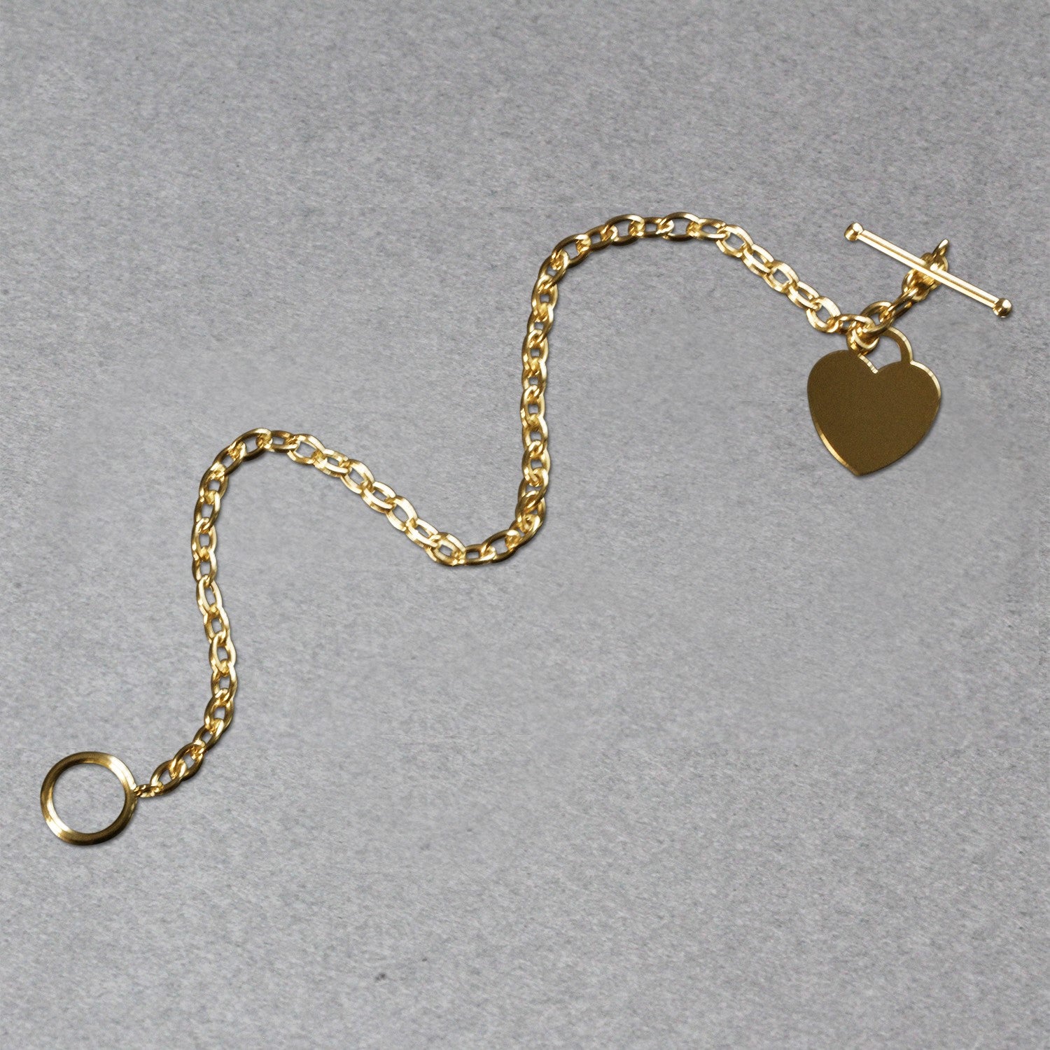 14k yellow gold toggle bracelet featuring a modern heart charm and elegant chain design.