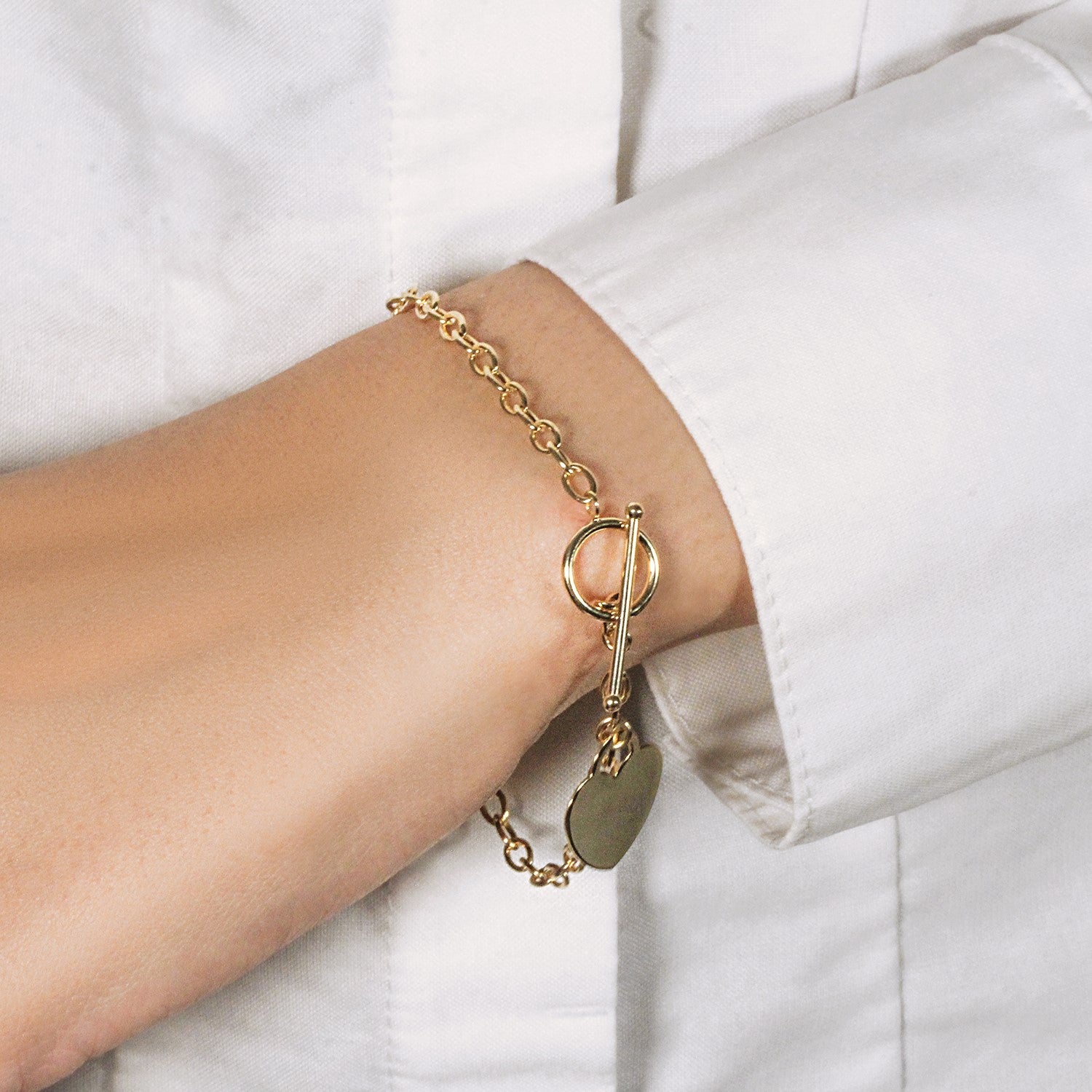 14k yellow gold toggle bracelet featuring a modern heart charm and elegant chain design.