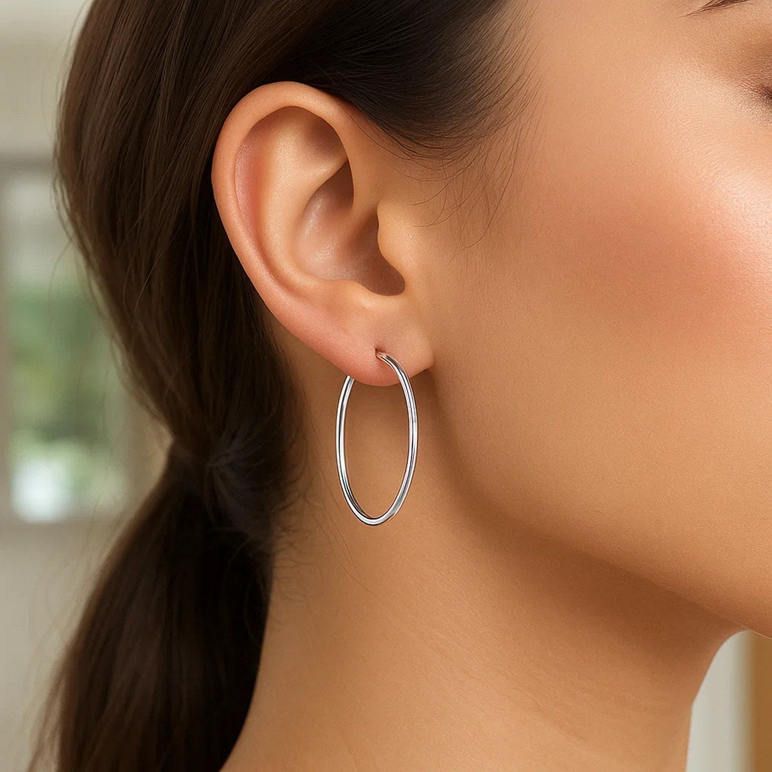 Polished 14k white gold hoop earrings with a modern design, showcasing elegance and timeless sophistication.