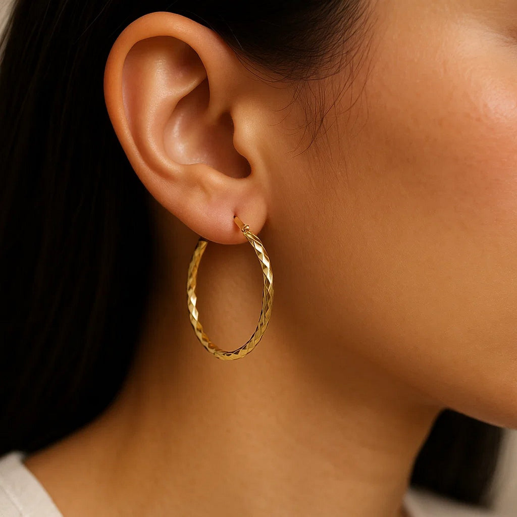 14k yellow gold slender hoop earrings with a diamond-cut finish, modern design, 25mm diameter, perfect for elegant occasions.