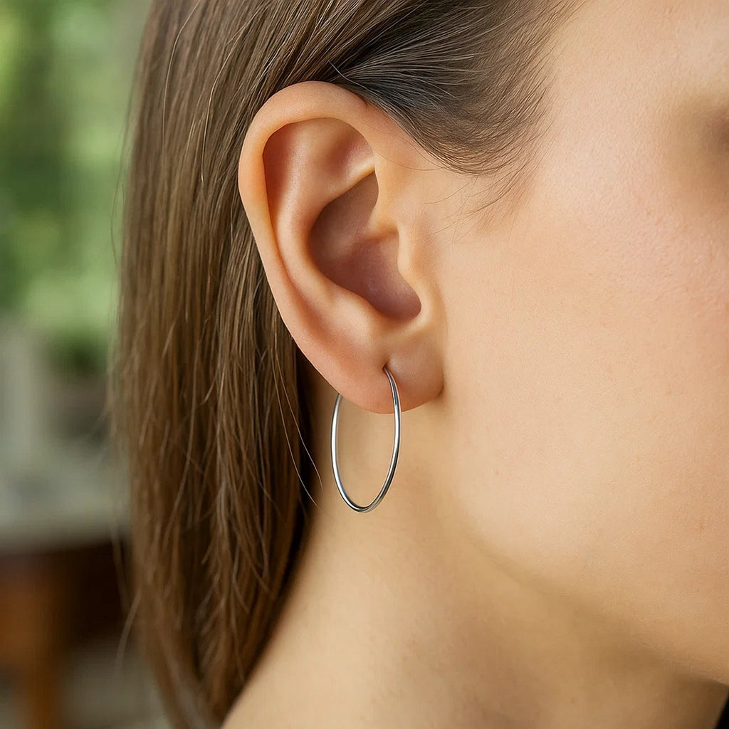 Polished 14k white gold hoop earrings with a modern design, showcasing elegance and timeless sophistication.