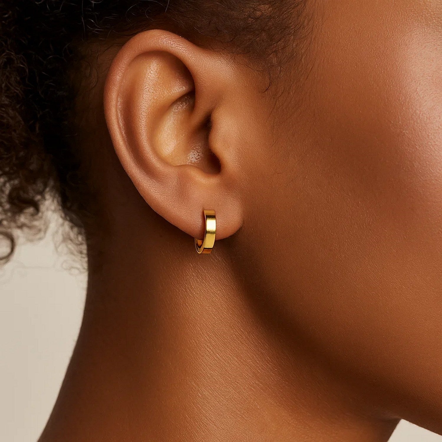 14k yellow gold small hoop earrings with a sleek modern design, perfect for elegant everyday wear.