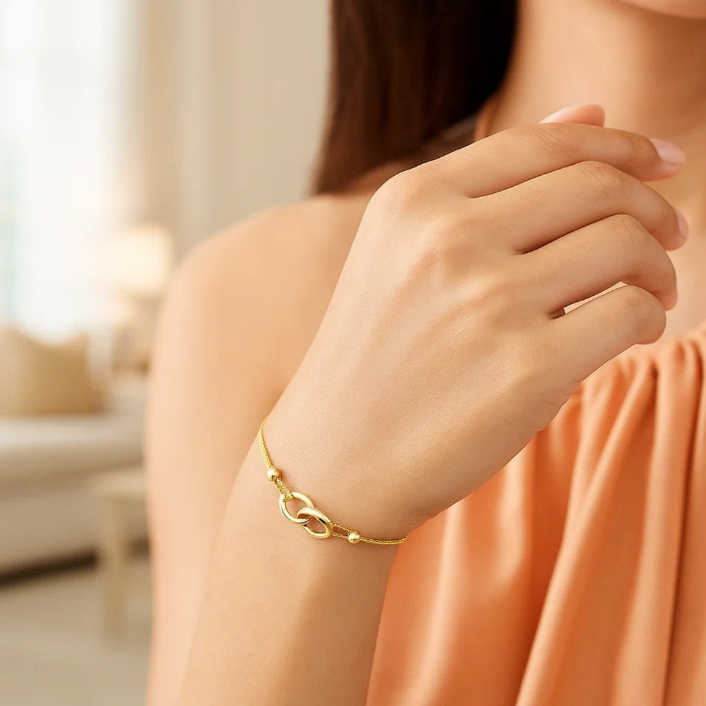 14k yellow gold adjustable lariat bracelet featuring entwined rings in a modern design, perfect for elegant layering.