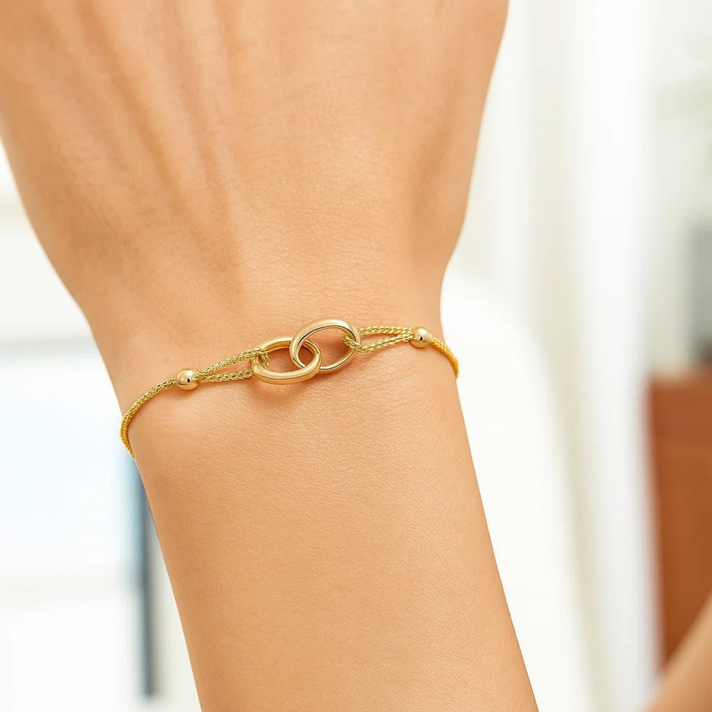 14k yellow gold adjustable lariat bracelet featuring entwined rings in a modern design, perfect for elegant layering.
