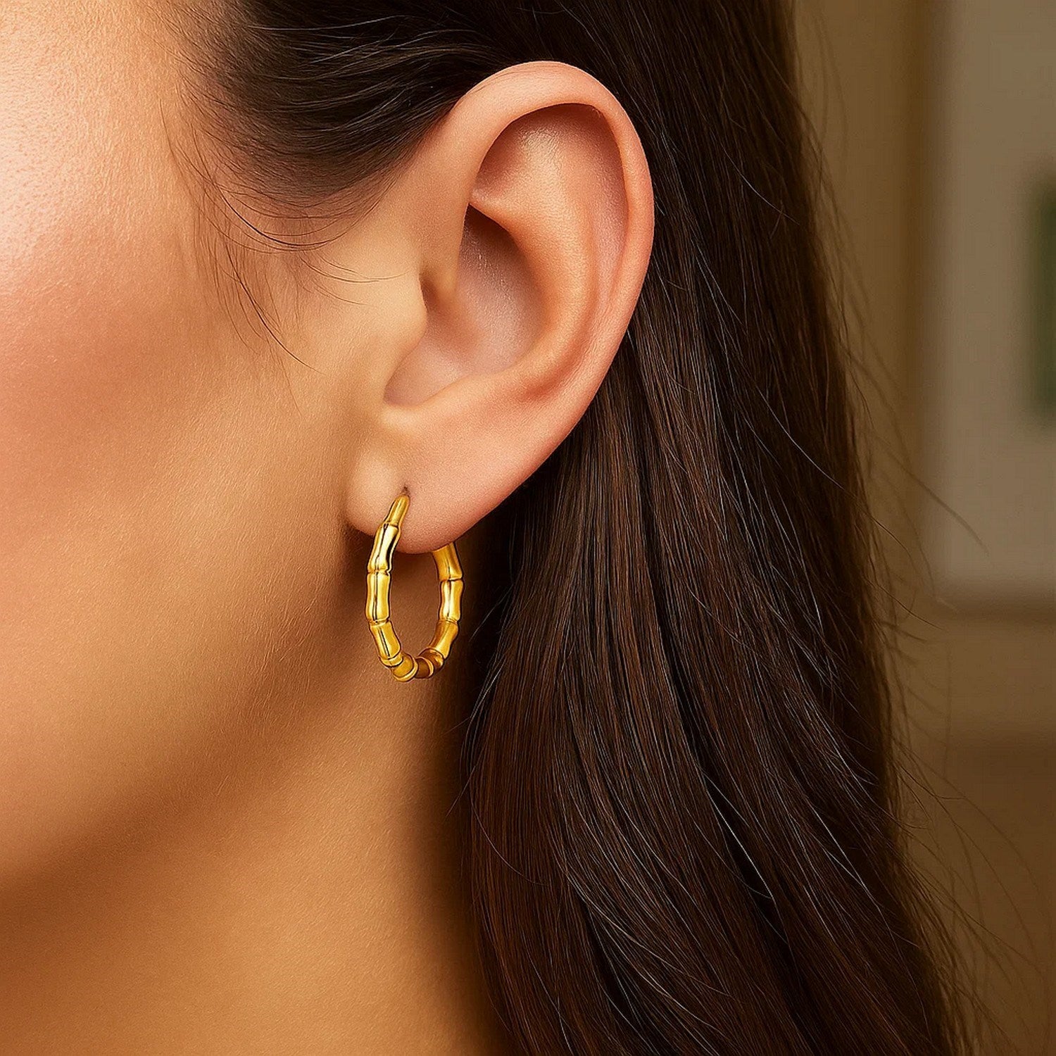 Contemporary 10k yellow gold hoop earrings featuring a unique branch motif and elegant oval design.