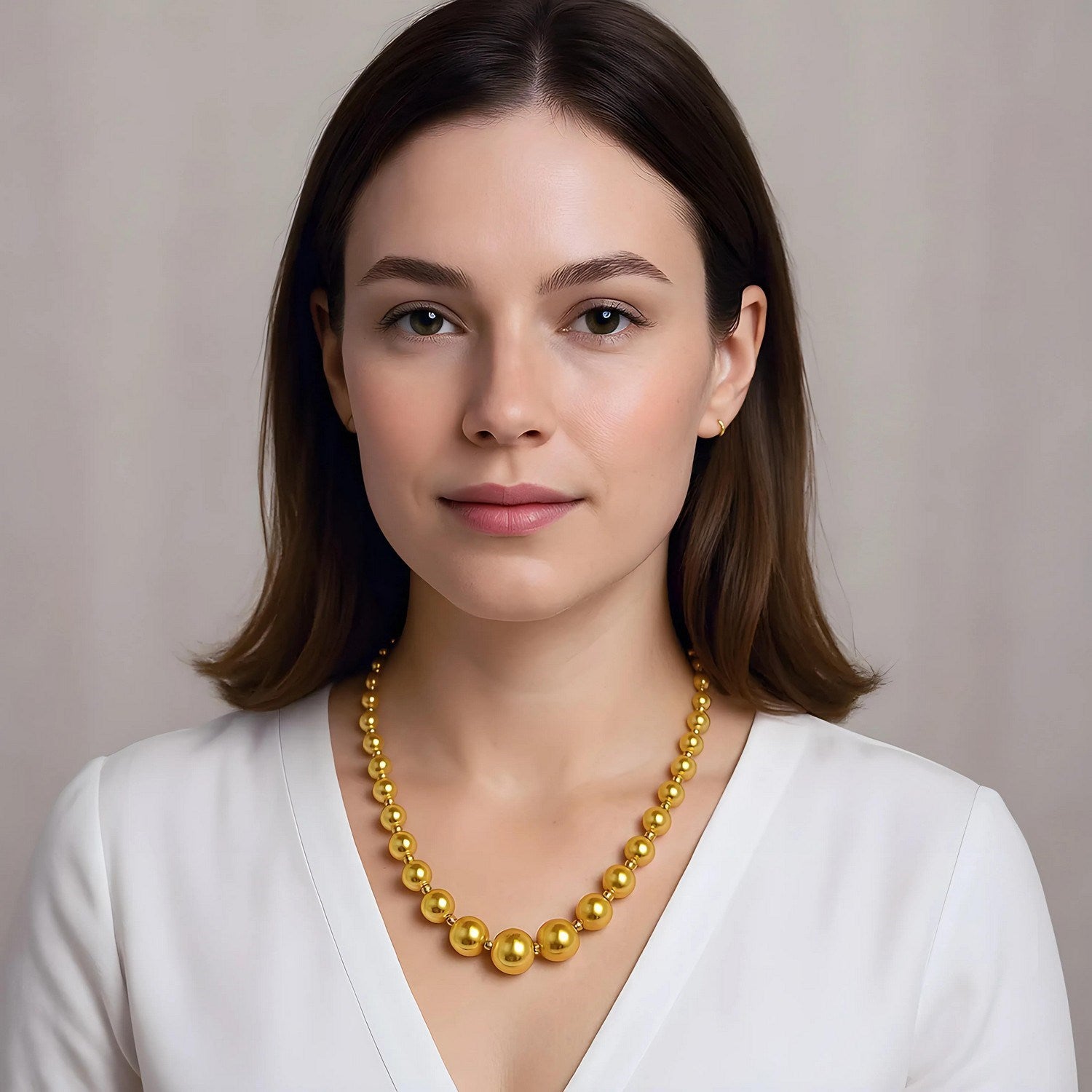 Graduated bead necklace in 14k yellow gold, featuring a modern design with elegant stud accents.