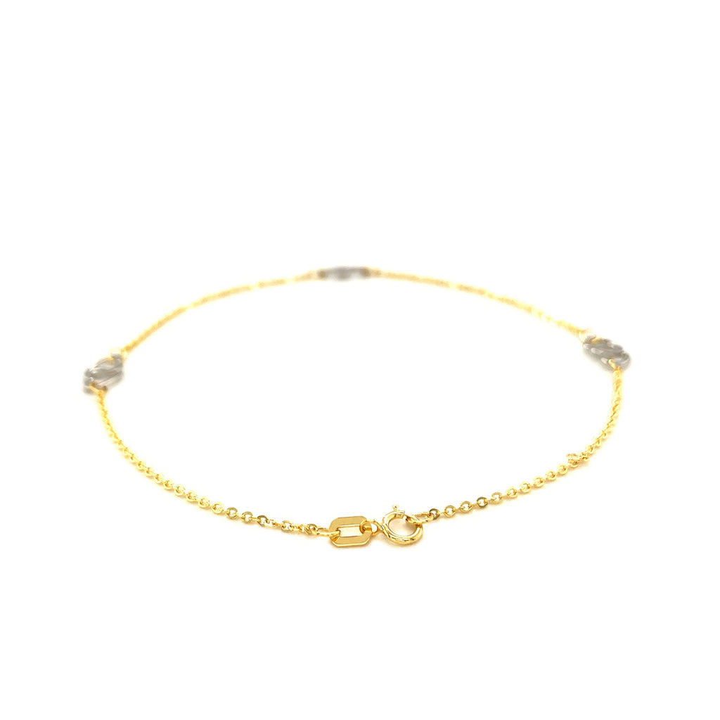 14k two-tone gold entwined heart anklet featuring a modern design, perfect for adding luxury to any outfit.