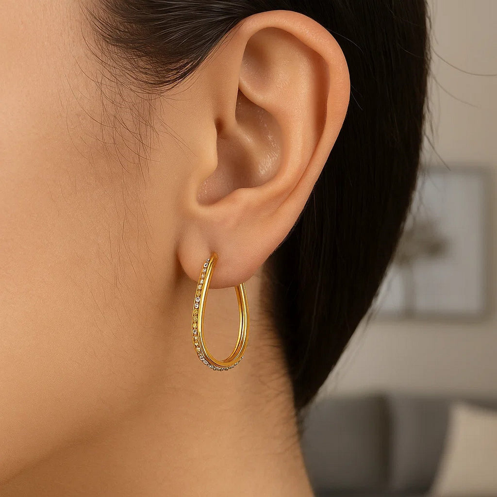 14k two-tone gold textured oval hoop earrings, showcasing a classic design with luxurious elegance.