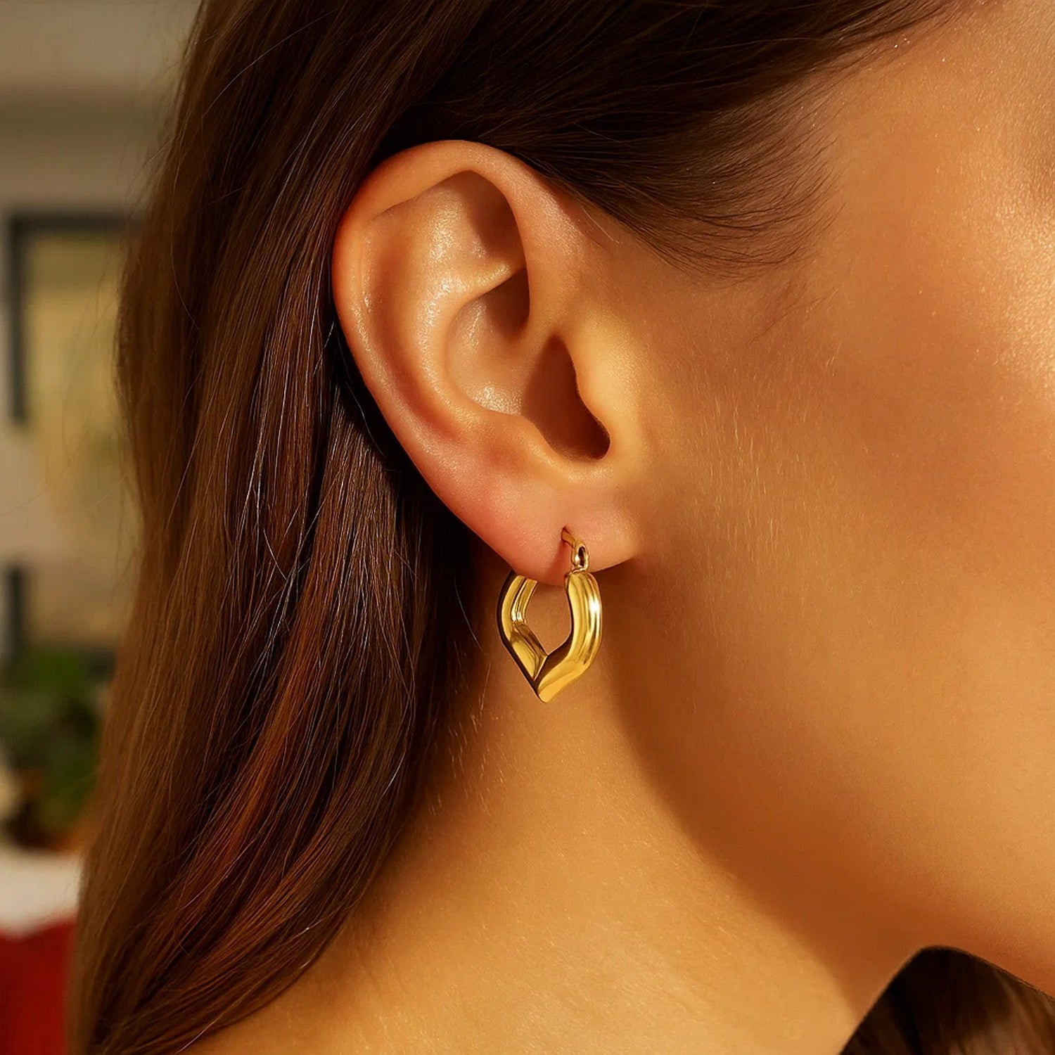 Heart-shaped hoop earrings in 14k yellow gold, showcasing a modern design and elegant craftsmanship.