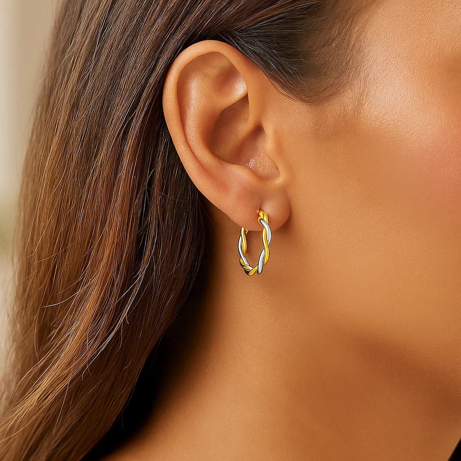10k yellow and white gold two-tone twisted wire hoop earrings with a contemporary design and elegant round shape.